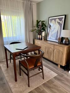 a living room with a wooden table and a table and chair at House with garden and parking 15 min to City Center in Edinburgh