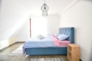茲拉蒂博爾的住宿－Brvnara Mont 3，一间卧室配有蓝色的床,铺有粉色和蓝色的床单