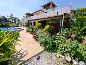 ein Haus mit einem Garten und einem Pool in der Unterkunft Bua Daeng Homestay Resort in Amphoe Kumphawapi