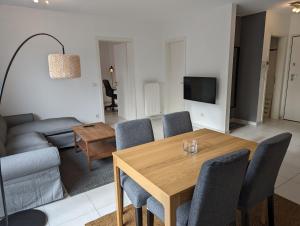 a living room with a table and a couch at 1BR Apartment with Garage in Kirchberg in Luxembourg