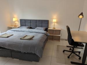 a bedroom with a bed with a desk and a chair at 1BR Apartment with Garage in Kirchberg in Luxembourg