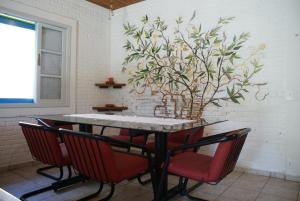 a dining room table with chairs and a plant on the wall at Casa Azul in São Sebastião