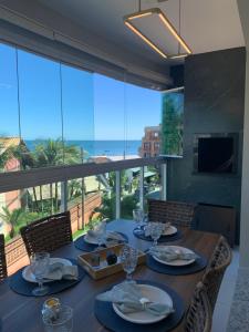 a dining room table with a view of the ocean at BORBOLETAS DO MAR in Bombinhas