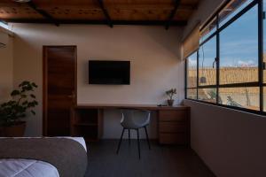 a bedroom with a desk and a tv and a window at Las Privadas / Casa X By Nardazul in Oaxaca City