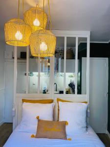 1 dormitorio con 2 almohadas blancas y 2 lámparas de araña en Le Germain - Coeur de ville, en Rennes