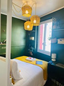 1 dormitorio con cama, escritorio y lámparas de araña en Le Germain - Coeur de ville, en Rennes