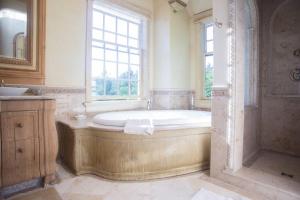 a large bathroom with a tub and a window at Adams Hill House Retreat - Artist-Architect's Estate, Newfane Vermont in Newfane