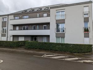 an apartment building with bushes in front of it at 1BR Apartment with Garage in Kirchberg in Luxembourg