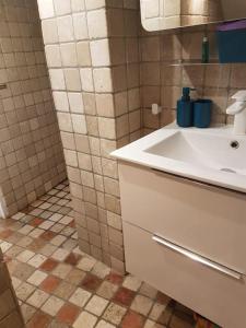 baño con lavabo blanco y suelo de baldosa. en Villa Caiou/ vue Mer/ Piscine/Jardin, en Le Rove