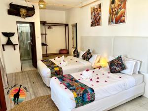 a hotel room with two beds and a living room at New Giraffe House in Vilanculos