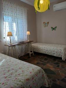 a room with two beds and a table with butterflies on the wall at Calma in Perdika