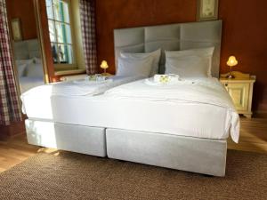 ein großes Bett mit weißer Bettwäsche und Kissen darauf in der Unterkunft Vitranc Boutique Hotel in Kranjska Gora