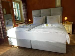 ein großes Bett in einem Schlafzimmer mit zwei Kerzen darauf in der Unterkunft Vitranc Boutique Hotel in Kranjska Gora