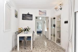 Biały korytarz z białym stołem i krzesłami w obiekcie Maison Lucienne w mieście Minori