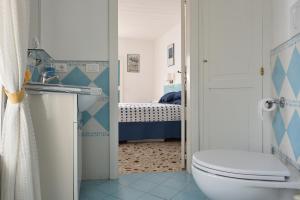 uma casa de banho com um WC e uma cama em Maison Lucienne em Minori