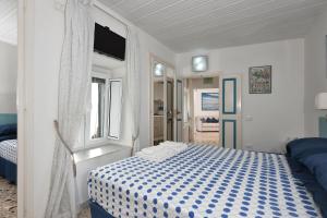 um quarto com uma cama azul e branca e uma janela em Maison Lucienne em Minori