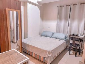 - une petite chambre avec un lit et un bureau dans l'établissement Chillhauz Staycation Cebu, à Cebu