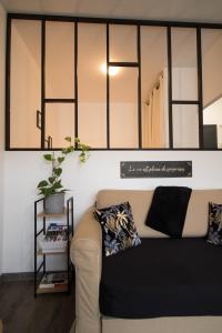 een woonkamer met een bank en een spiegel bij Breuil Station, studio tout confort in La Mure