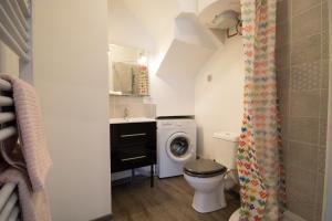 een badkamer met een toilet, een wastafel en een wasmachine bij Breuil Station, studio tout confort in La Mure
