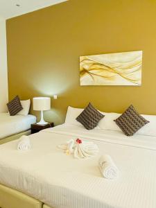 - une chambre d'hôtel avec 2 lits et des serviettes dans l'établissement The Cave, à Negombo