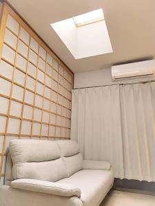 a living room with a couch and a skylight at R House 川越 in Kawagoe
