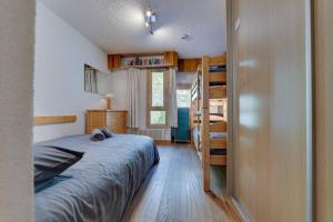 a bedroom with a bed and a bunk bed and a ladder at FRANCHET B 34 in La Daille