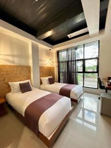 2 camas en una habitación de hotel con 2 camas sidx sidx sidx en Koze Suites, en Dumaguete