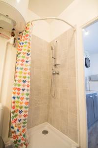 een douche met een douchegordijn in de badkamer bij Breuil Station, studio tout confort in La Mure