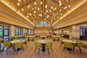 a dining room with tables and chairs and a ceiling with chandeliers at Four Points by Sheraton Hainan, Qiongzhong in Qiongzhong