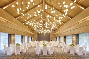a large banquet hall with white tables and white chairs at Four Points by Sheraton Hainan, Qiongzhong in Qiongzhong