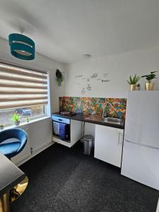 uma cozinha com um balcão, um lavatório e uma janela em Large Stylish 2 Bedroom Apartment Stevenage Sleep 6 em Stevenage