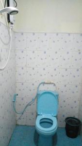a bathroom with a toilet with a blue seat at Tree Cool Resort in Ella