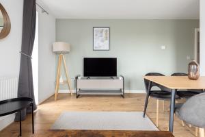 a living room with a television and a table at The Colindale Collection in Colindale