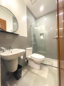 a bathroom with a toilet and a sink and a shower at Koze Suites in Dumaguete
