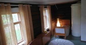 Habitación con 2 ventanas, 1 cama y 1 mesa. en Cozy cottage by the lake, en Lohja