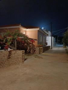 a house at night with a stone wall at Calma in Perdika