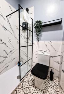 a bathroom with a black toilet and marble walls at Nice and comfy 1 bedroom apartment! in Liverpool