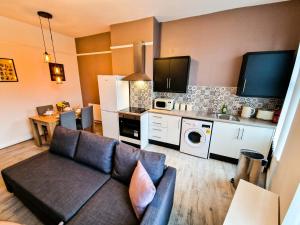 a living room with a couch and a kitchen at Nice and comfy 1 bedroom apartment! in Liverpool