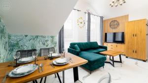 a living room with a green couch and a table at Apartamenty Good Time - Hugo Apartments - blisko centrum in Szklarska Poręba
