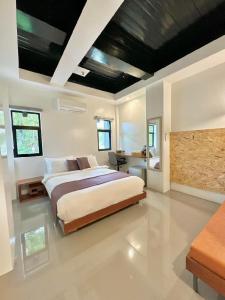1 dormitorio con 1 cama grande y escritorio en Koze Suites, en Dumaguete