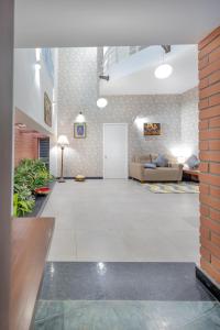 a large living room with a couch and a door at Ixora Suites in Bangalore