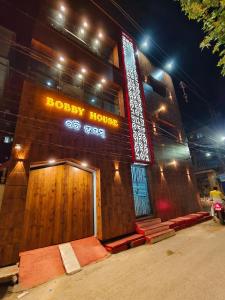 um edifício com uma porta de madeira e um sinal nele em Hotel Bobby house em Puri