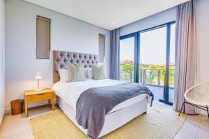 a bedroom with a bed and a large window at Oceans Edge 3, Zimbali Estate in Ballito