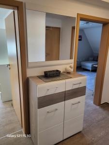 a bathroom with a dresser with a mirror on it at Apartment Bochum in Bochum +30 photos