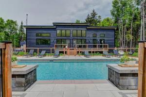 een huis met een zwembad ervoor bij Nouveau - Chalet moderne - Spa, piscine & sauna! in Pont-Rouge