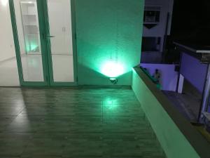 a green light on a wall next to a door at White Rooms by Sineth in Ratmalana