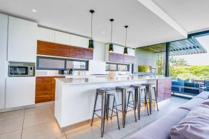 a kitchen with a bar with stools at Oceans Edge 3, Zimbali Estate in Ballito