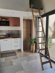 a kitchen with a ladder in the middle of a kitchen at Studio en campagne in Avignon