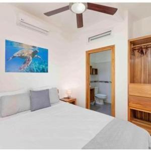 a bedroom with a white bed with a bird on it at Sir Sea Villas of Roatan LionFish 1 Bed 1 Bath in Roatán