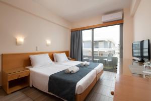 a hotel room with a bed and a large window at Nafsika Hotel in Rhodes Town